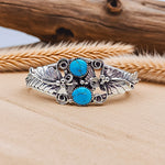 Silver bracelet with turquoise stones on a wooden surface