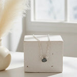 Ocean raw diamond necklace by Indie and Harper in sterling silver, full chain displayed on stone block