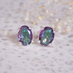 Pair of purple gemstone earrings on a light background