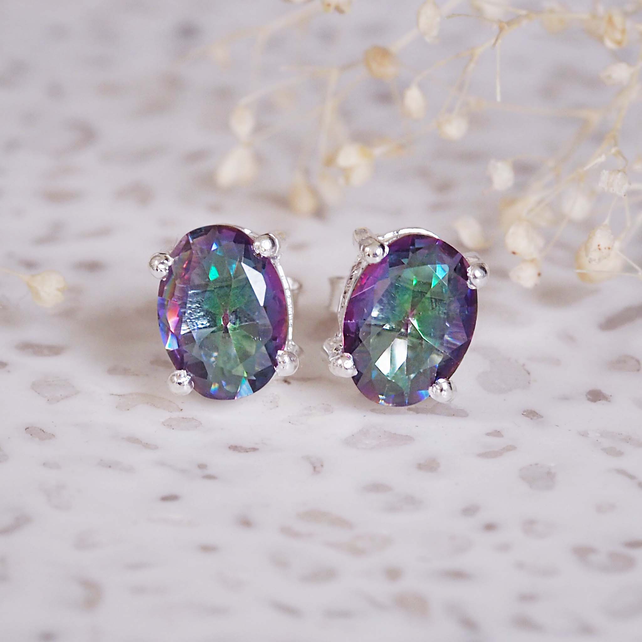 Pair of purple gemstone earrings on a light background
