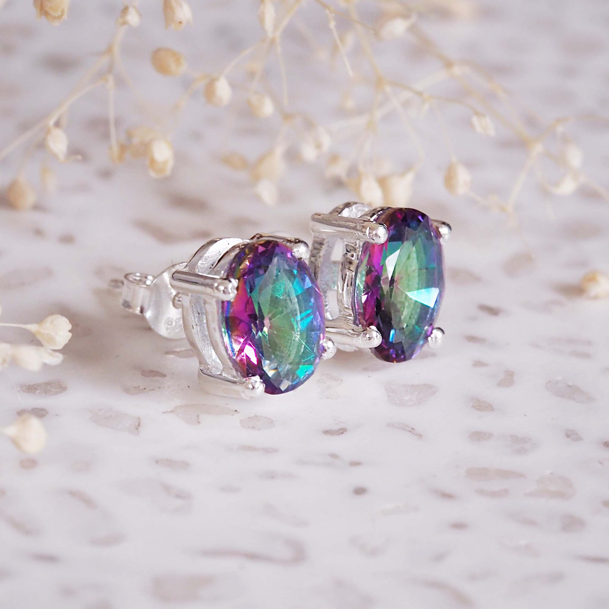 Multicolored gemstone earrings on a light background