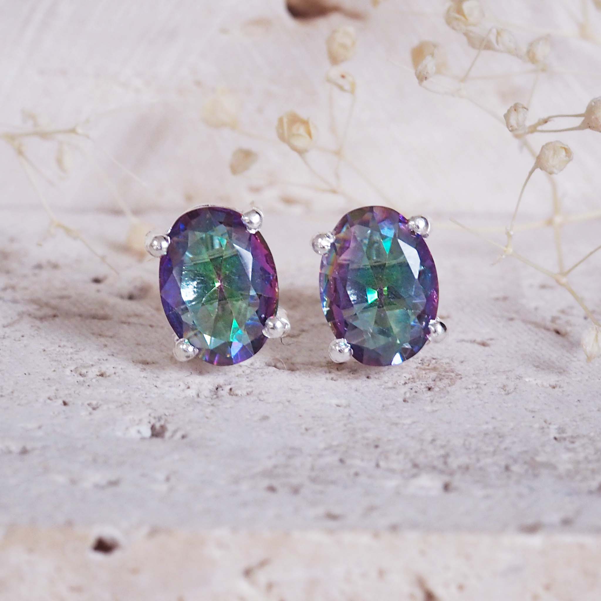 Pair of purple gemstone earrings on a light background