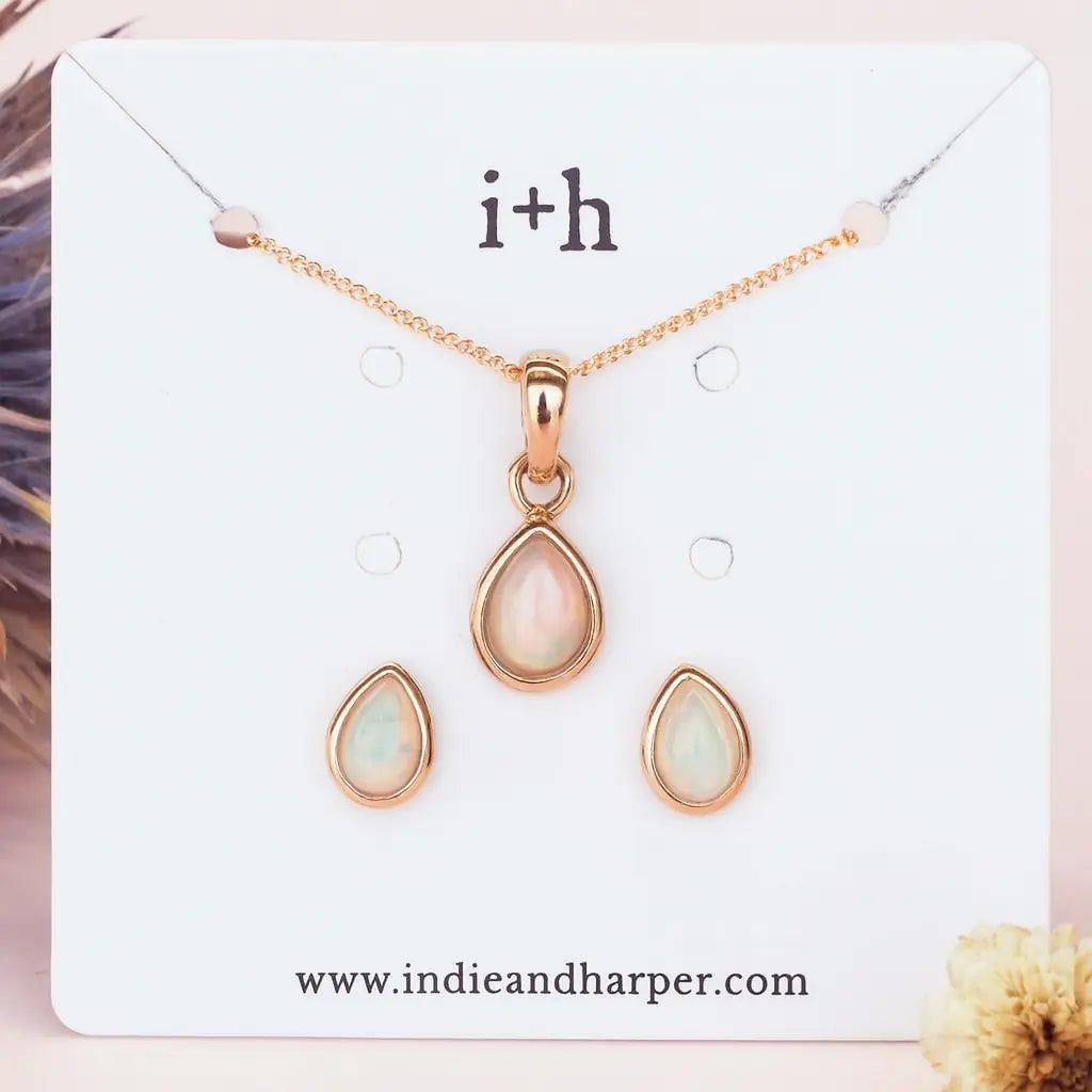 october birthstone opal Jewelry set with rose gold teardrop pendant and earrings on a branded card, featuring 'i+h' and www.indieandharper.com.