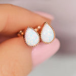 rose gold tear drop white opal stud earrings being held - indie and harper australia