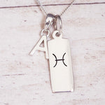 Silver necklace with a pendant featuring a zodiac symbol on a light wooden background