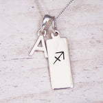 Silver necklace with a pendant featuring an 'A' and a sagittarius symbol on a light background