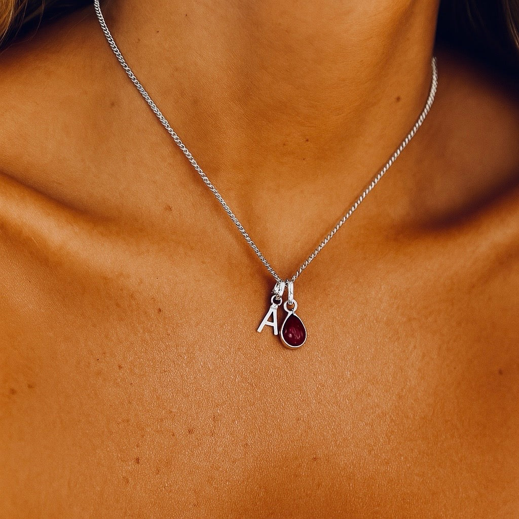 indie and harper sterling silver initial and january birthstone garnet necklace being worn