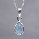 Teardrop-shaped pendant with blue topaz stone on a silver chain against a gray background