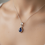 Teardrop-shaped blue gemstone necklace on a woman