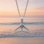 indie and harper Sterling Silver Whale tail necklace against a beach sunset background 