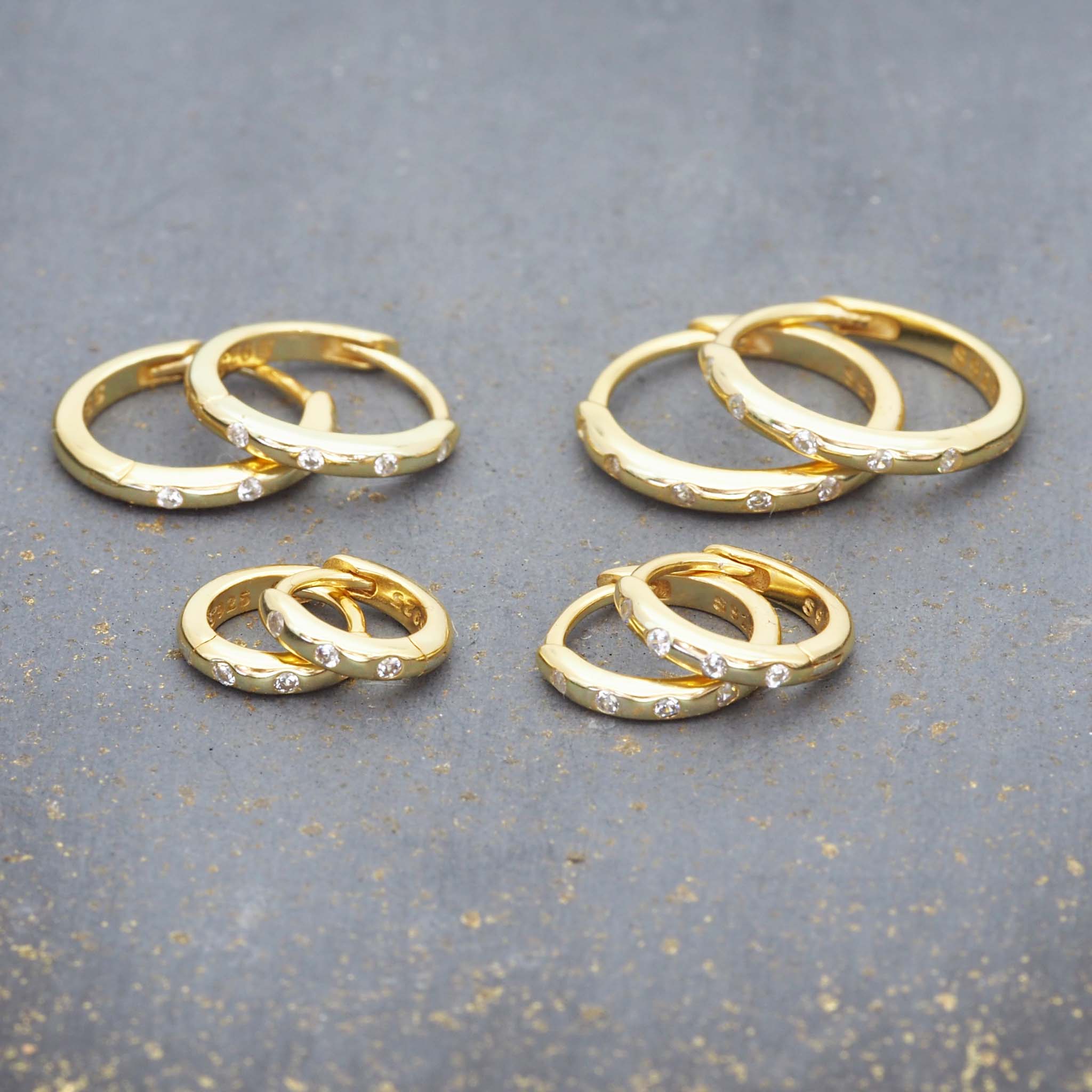 indie and harper gold hoop style earrings with dainty cubic zirconias in four different size hoops
