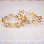 Gold hoop earrings with butterfly designs on a light background