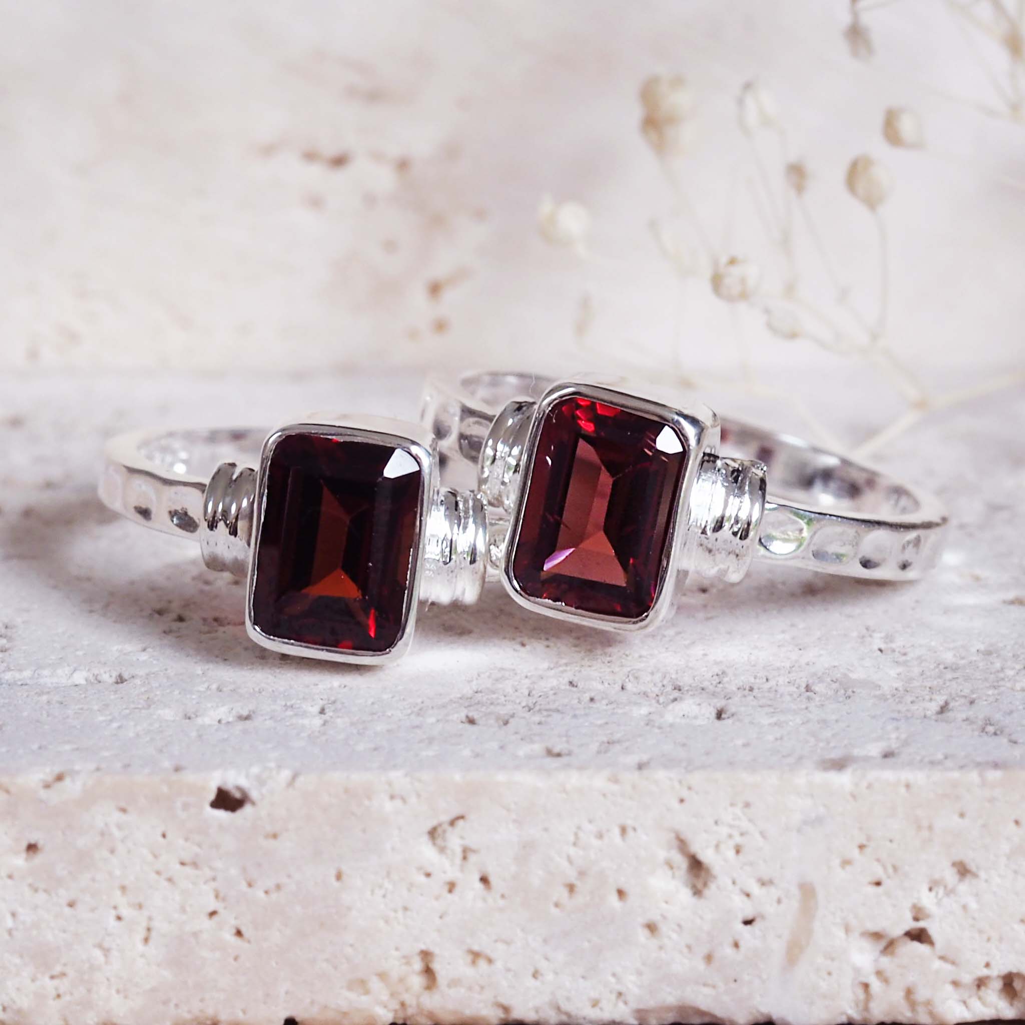 indie and harper silver silver rings with red gemstones on a textured surface