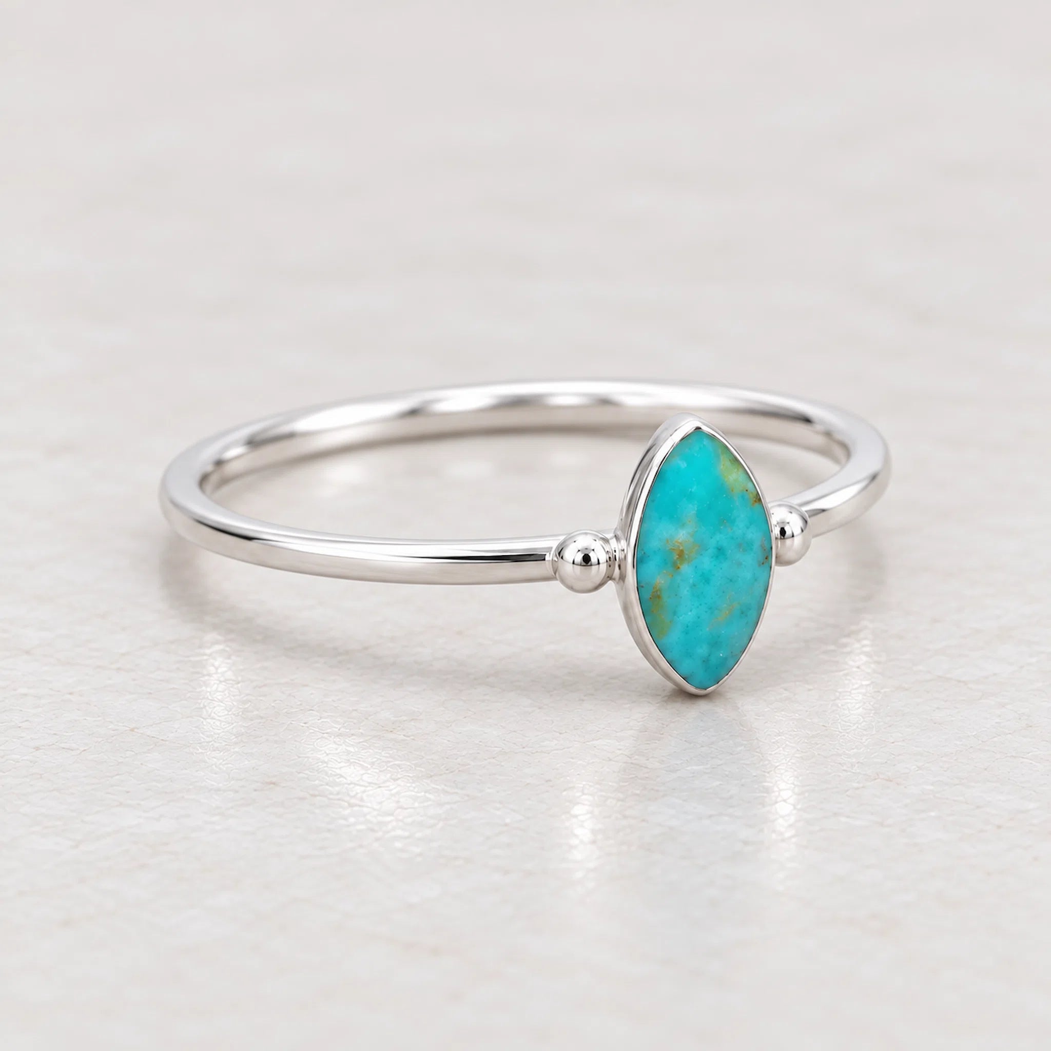 sterling Silver ring with a turquoise stone on a pebble