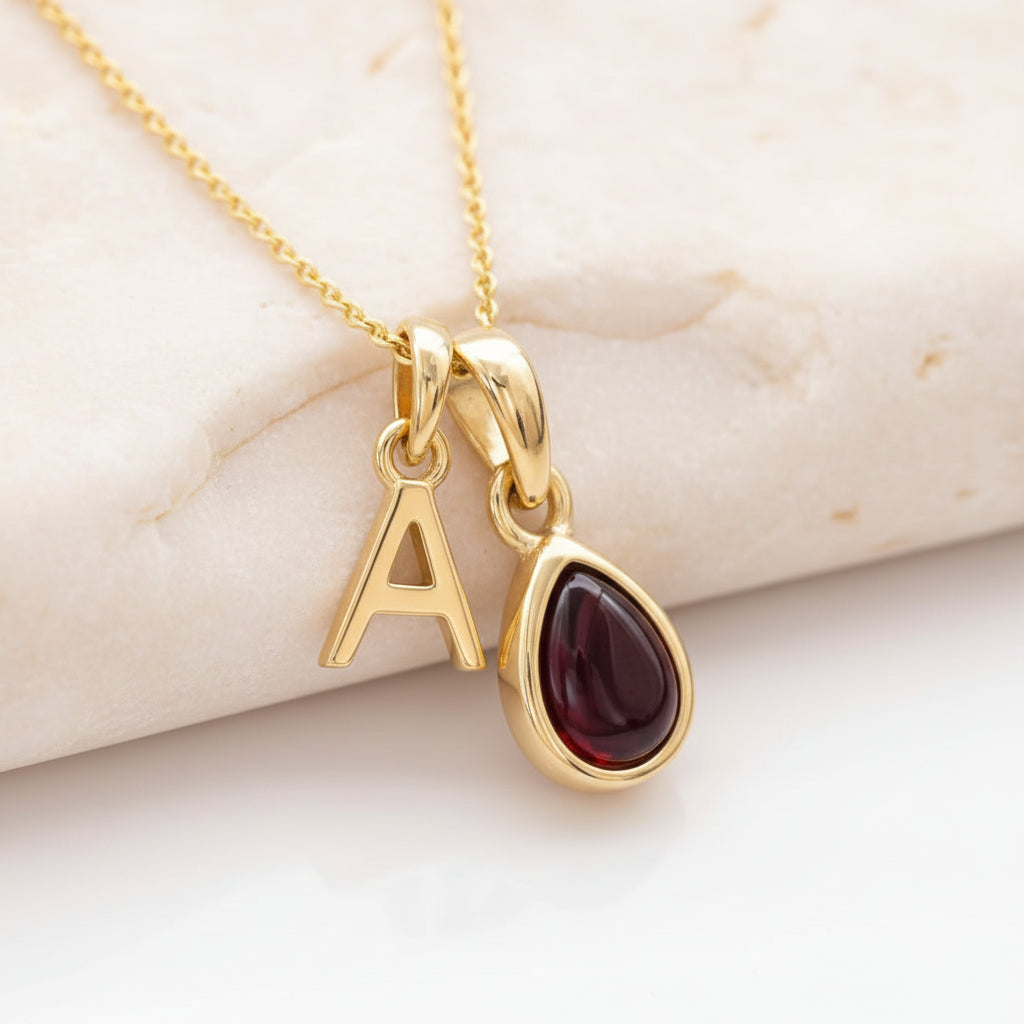 Gold initial and January birthstone garnet necklace on a 9k gold plated chain.