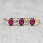 July Birthstone ruby Rings in rose gold, silver and gold on a wooden surface