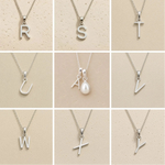 Collection of silver necklaces with initial pendant R to Y on a beige background as personalised letter options to add to a June Birthstone Mother of Pearl Necklace.