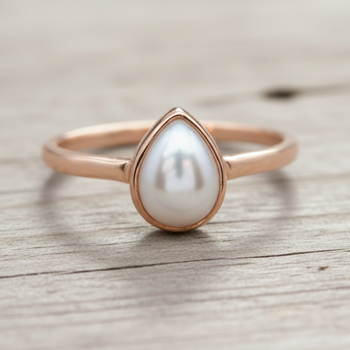 Pearl ring with rose gold setting on a white background