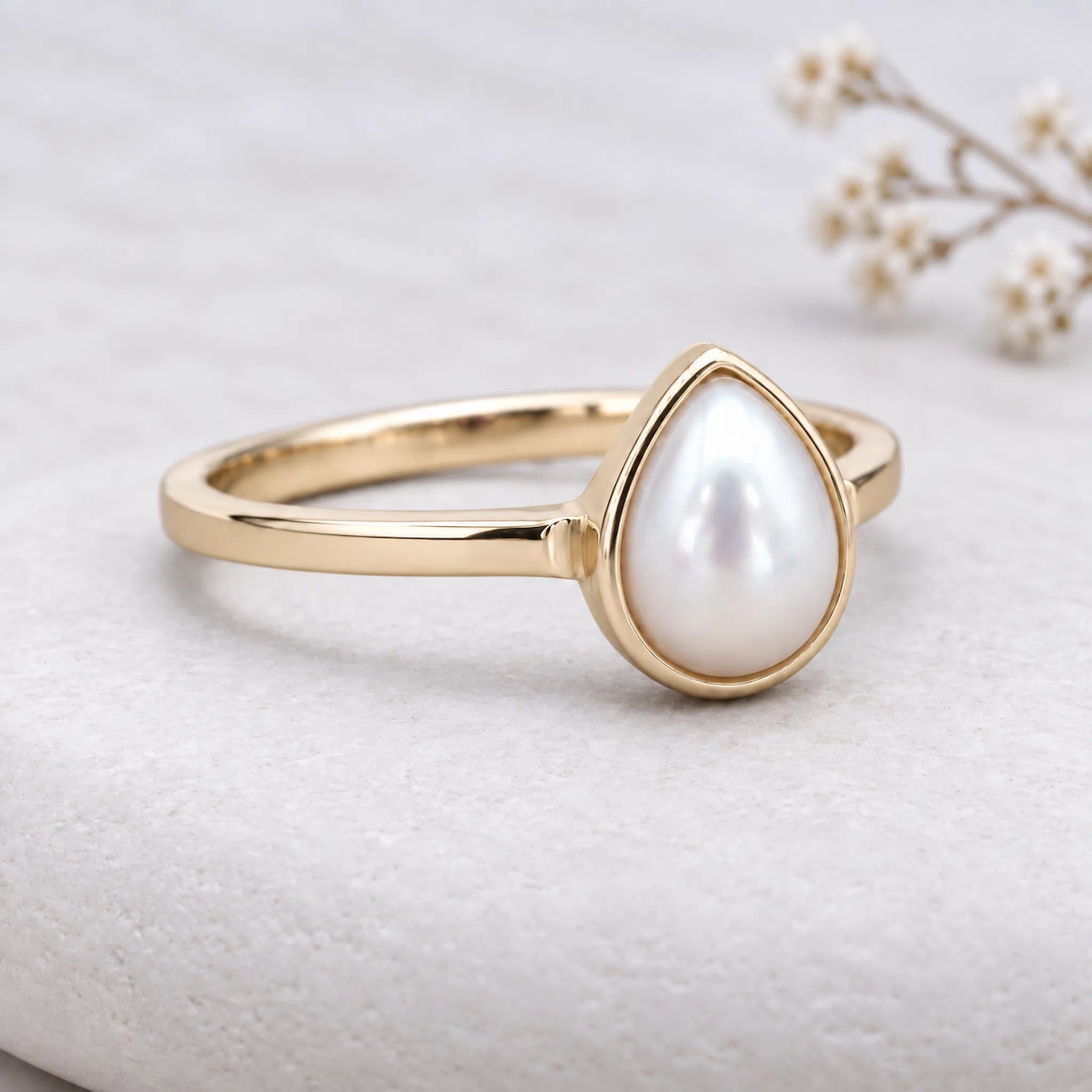 gold june birthstone ring featuring a Pear-shaped natural mother of pearl in bezel-set gold plating, featuring a smooth bezel setting and a slim band design.