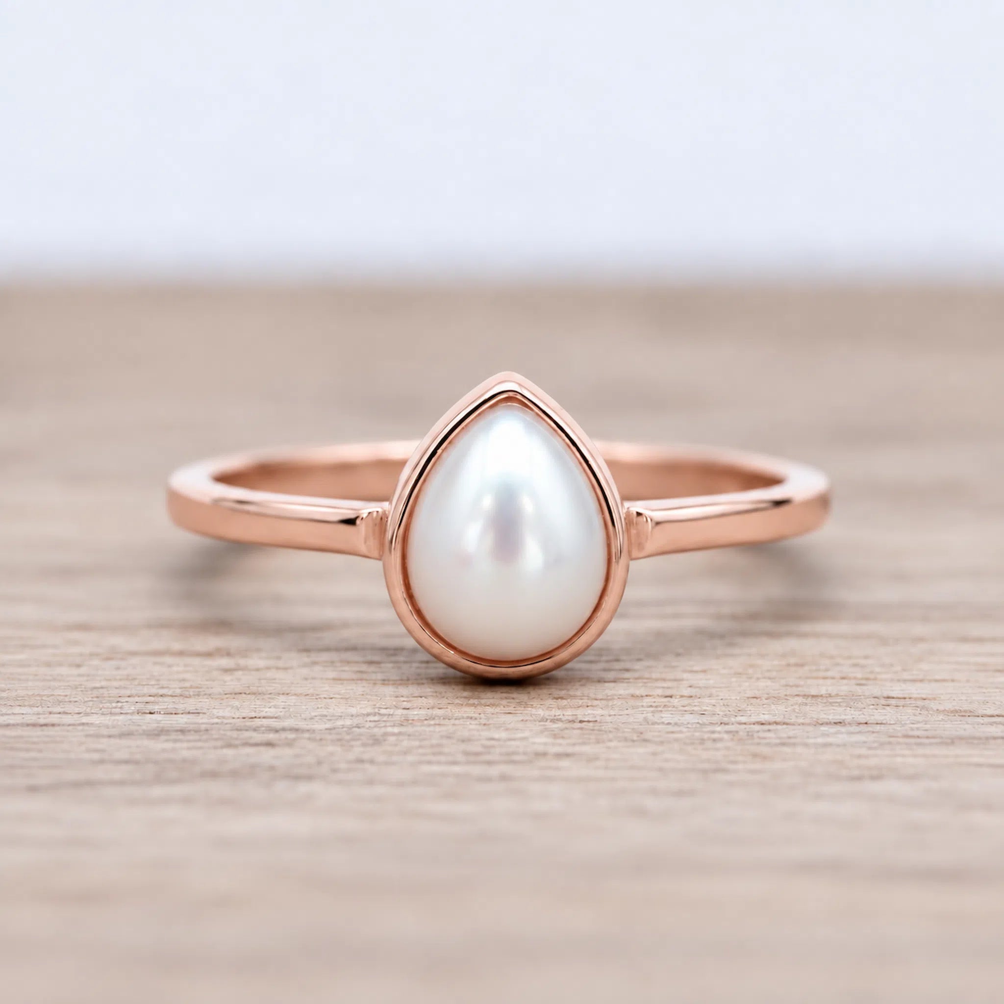 Natural Mother of Pearl June Birthstone Ring featuring a pear-shaped stone set in a 9k rose gold band.
