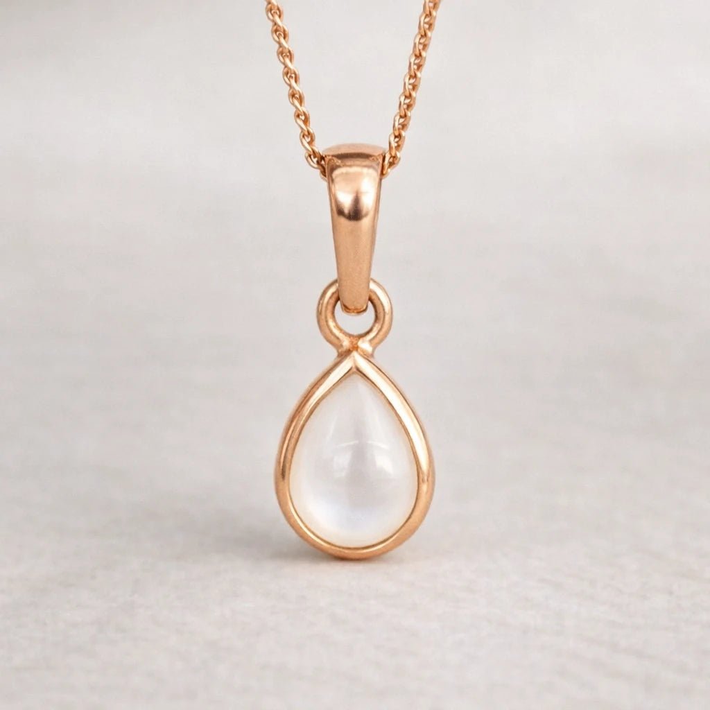 Rose gold teardrop pearl pendant necklace on a light gray background