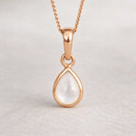 Rose gold teardrop pearl pendant necklace on a light gray background