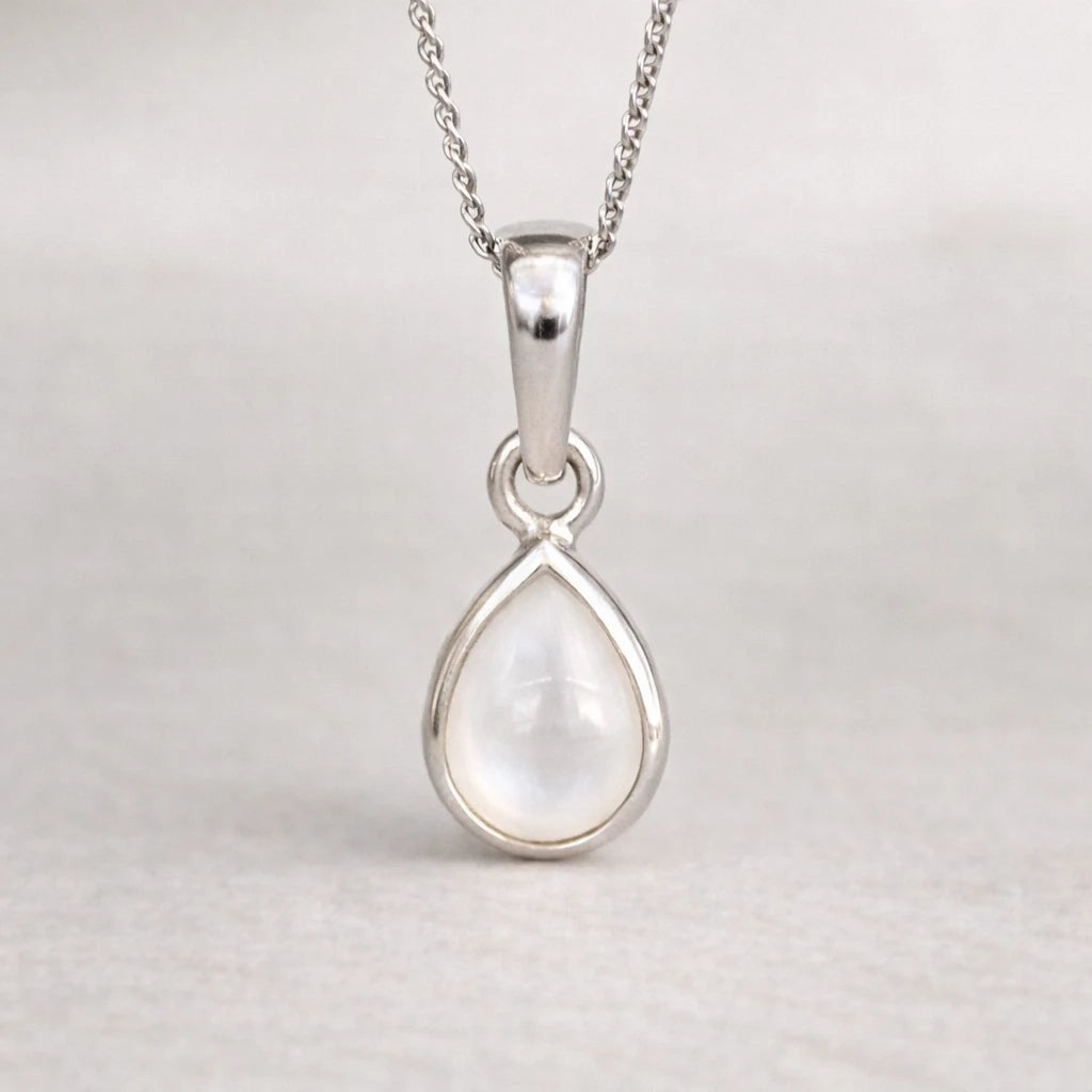 Silver teardrop pendant on a chain against a light gray background