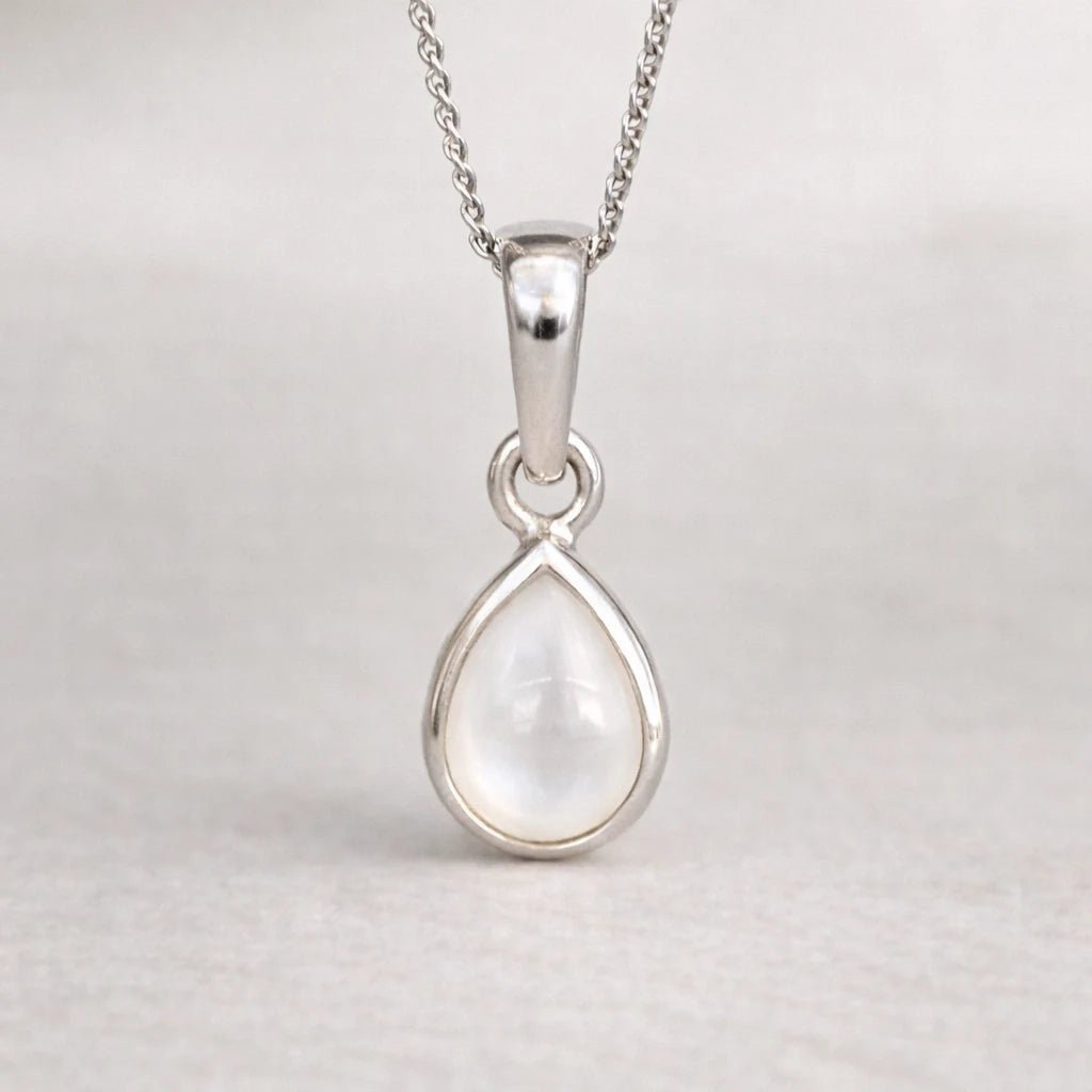Silver teardrop pendant on a chain against a light gray background