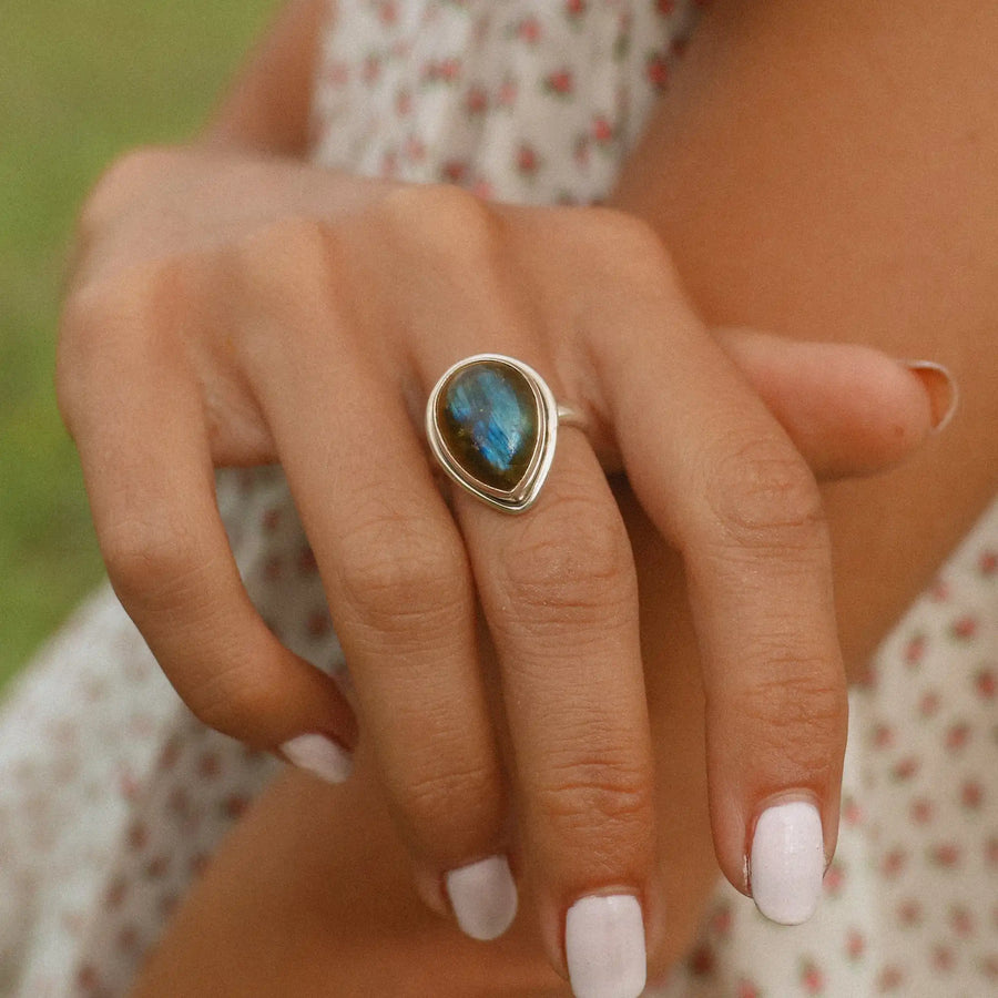 woman wearing sterling silver ring with teardrop shaped labradorite stone