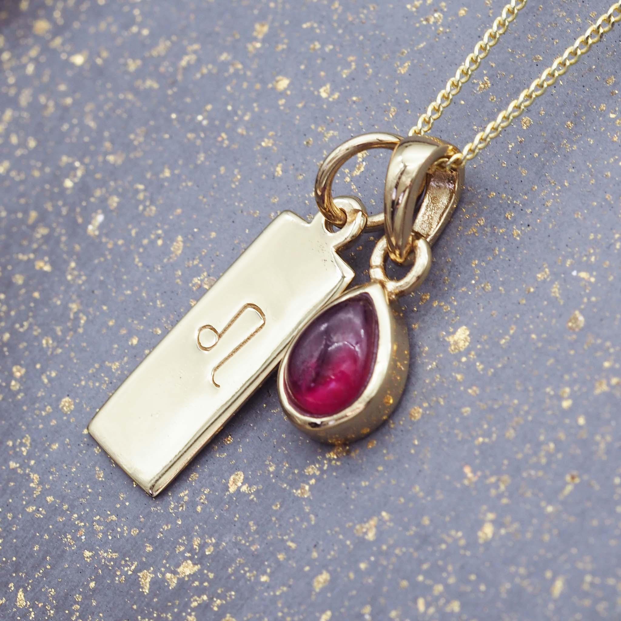 Gold Leo star sign necklace with a deep red genuine ruby July birthstone charm by indie and Harper