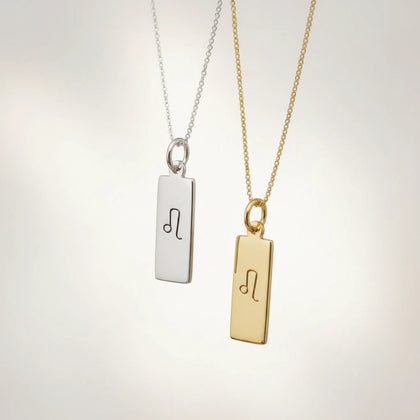 Gold and silver necklaces with leo zodiac pendants on a white background