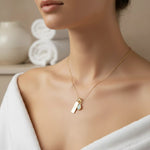 Gold libra zodiac and october birthstone opal necklace on a person wearing a white towel.