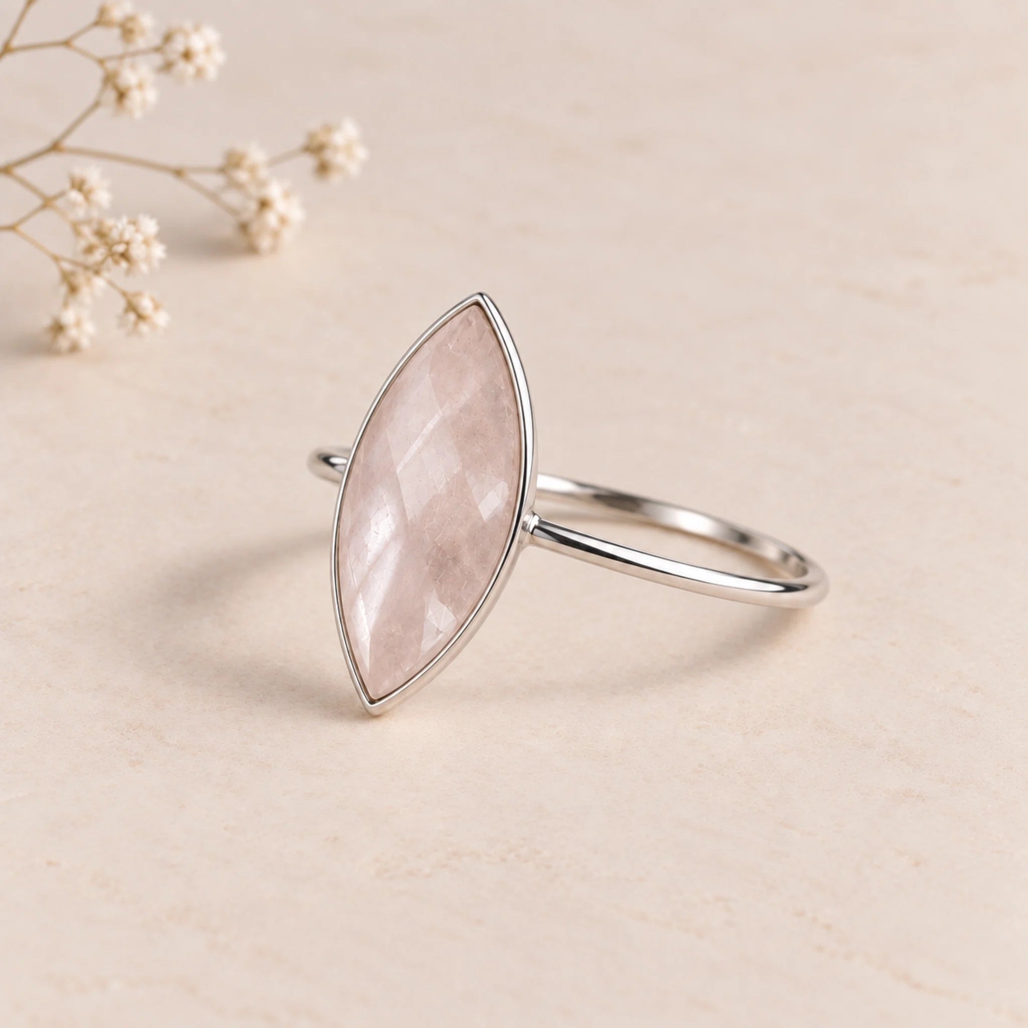 side image of a sterling silver rose cut, bezel set, marquise shaped natural rose quartz ring