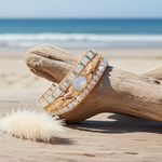 beaded moonstone bracelet by indie and harper on a piece of driftwood with a beach background
