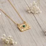 Malachite Evil Eye Waterproof Gold Necklace in stainless steel on a light wooden surface