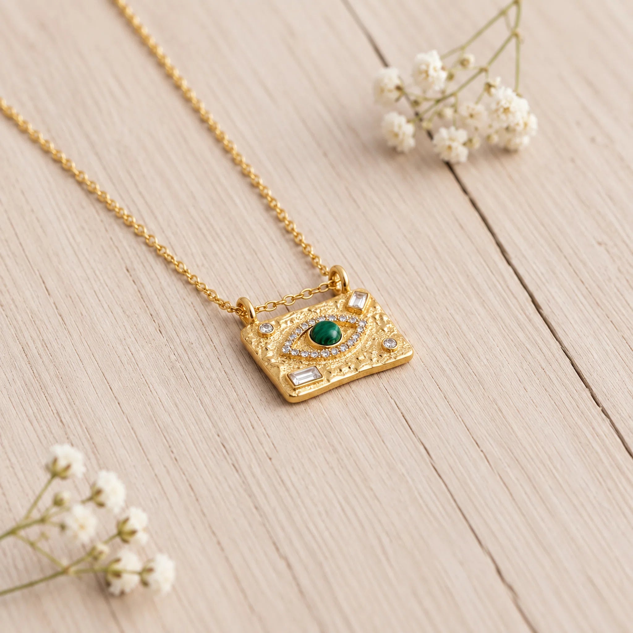 Malachite Evil Eye Waterproof Gold Necklace in stainless steel on a light wooden surface