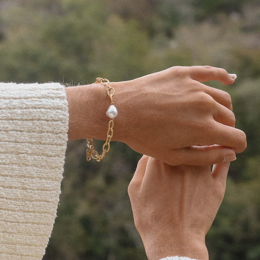 Woman wearing a white jumper and Gold Bracelet with freshwater pearl - womens gold waterproof jewellery australia
