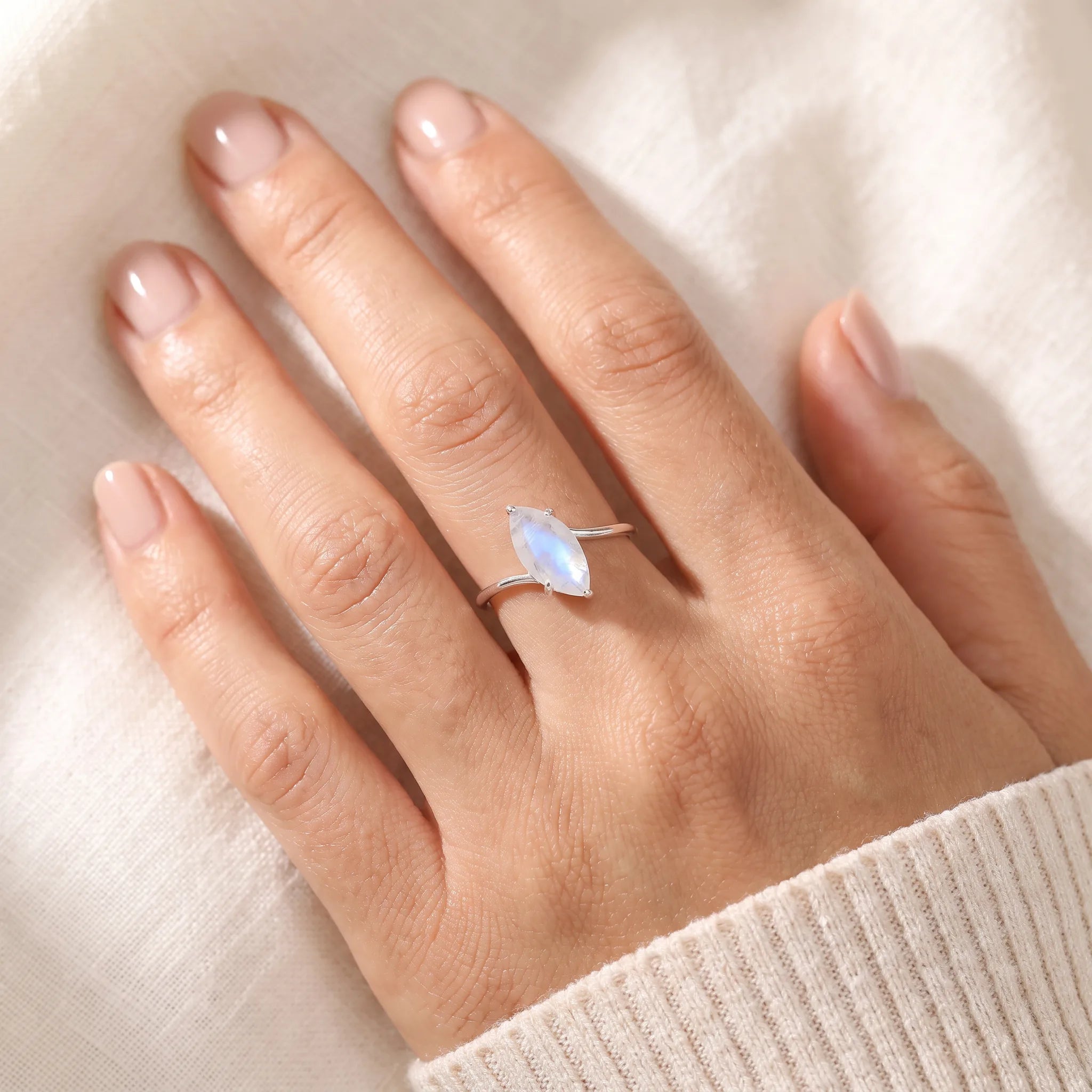 Marquise rainbow moonstone ring worn on hand, faceted moonstone on a thin silver wrap band