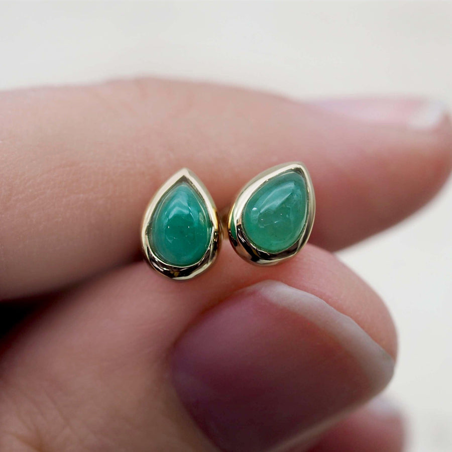 may birthstone earrings - gold and emerald earrings being held - womens may birthstone jewellery australia