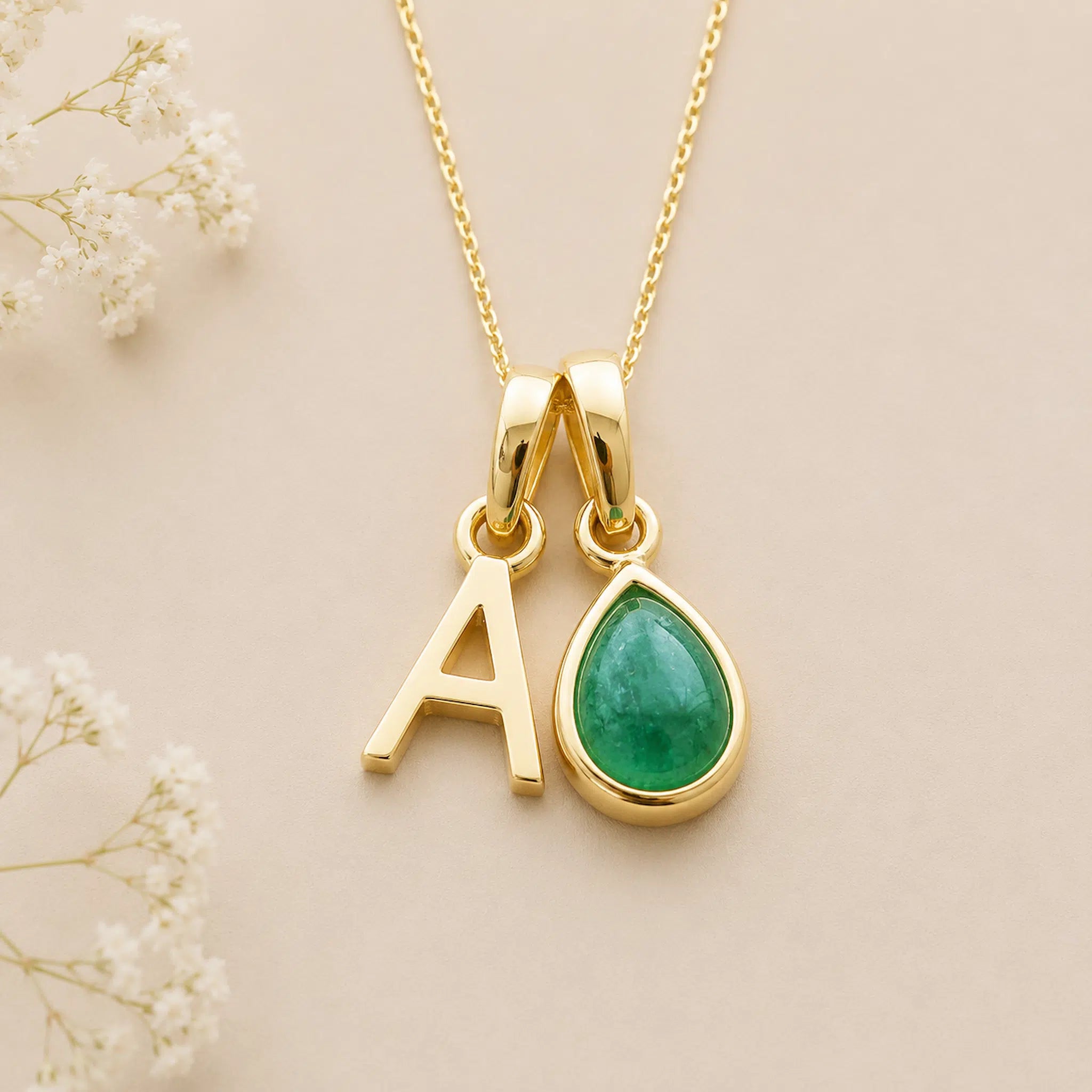 gold may birthstone necklace with pear-shaped natural emerald gemstone and gold initial A pendant