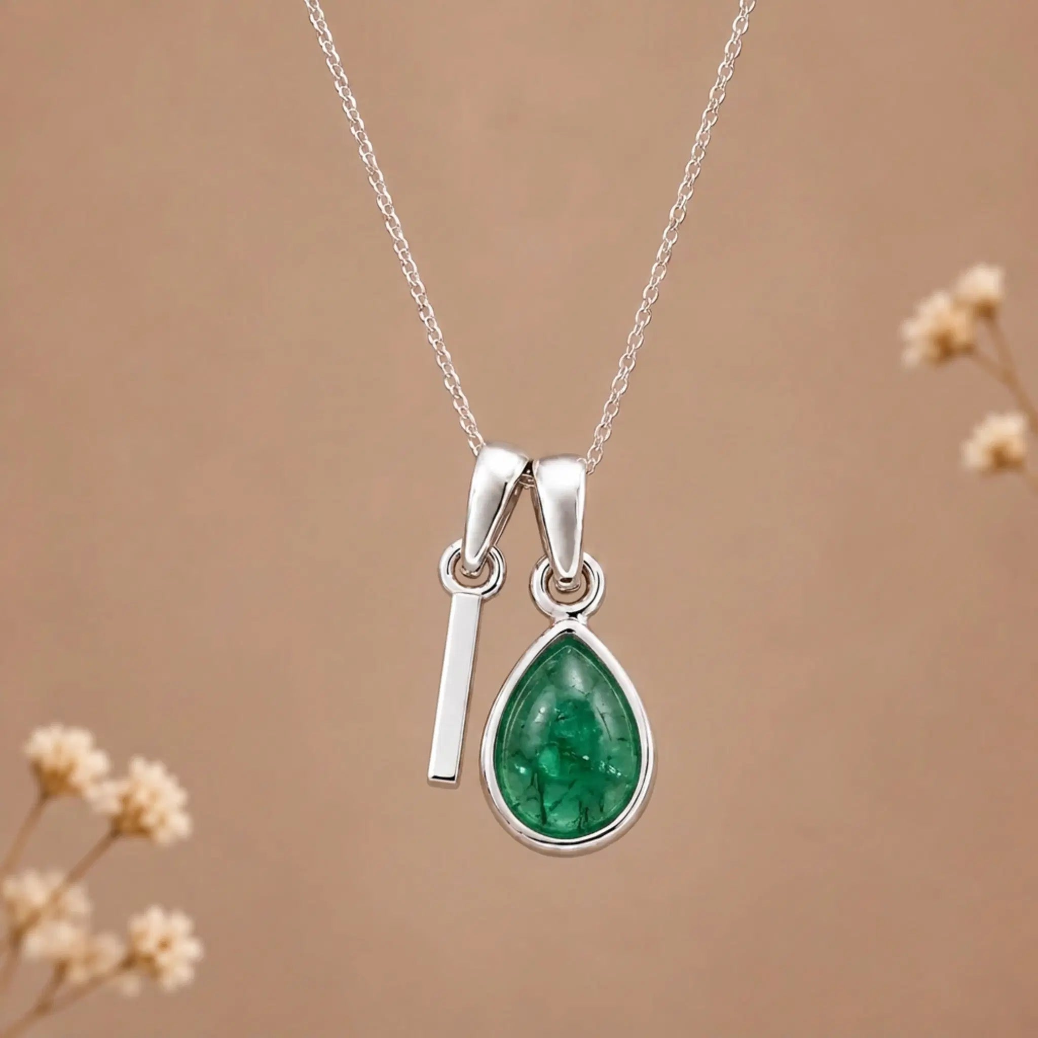 sterling silver initial i may birthstone natural emerald pendant necklace against a dark warm beige background