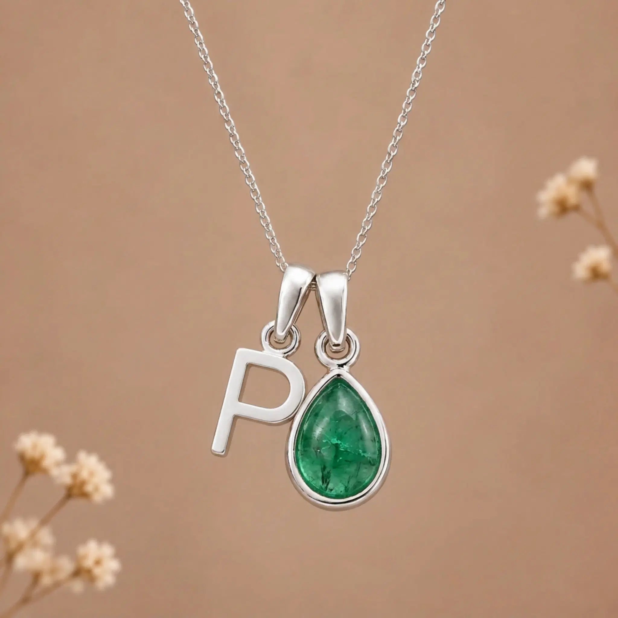 sterling silver initial p may birthstone natural emerald pendant necklace against a dark warm beige background