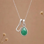 sterling silver initial u may birthstone natural emerald pendant necklace against a dark warm beige background