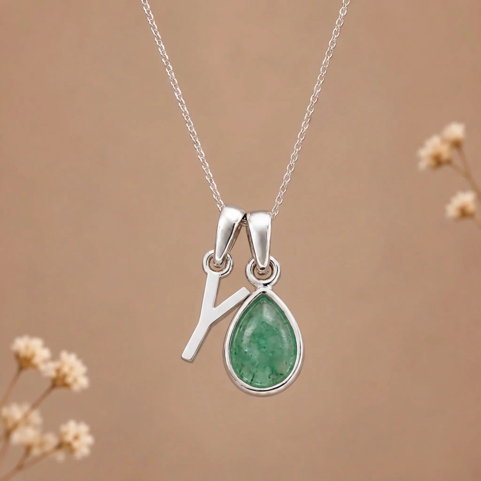 sterling silver initial y may birthstone natural emerald pendant necklace against a dark warm beige background