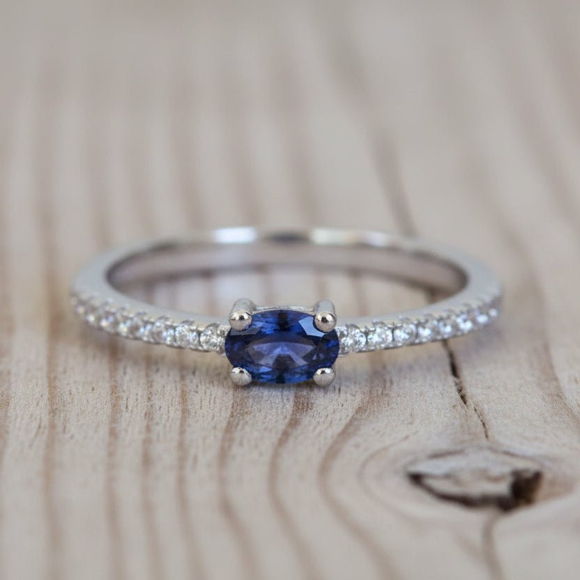 Ring with a blue gemstone and diamond accents on a textured surface