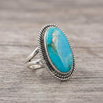 side view of a Sterling Silver Boho Ring with mohave turquoise gemstone on a wooden surface