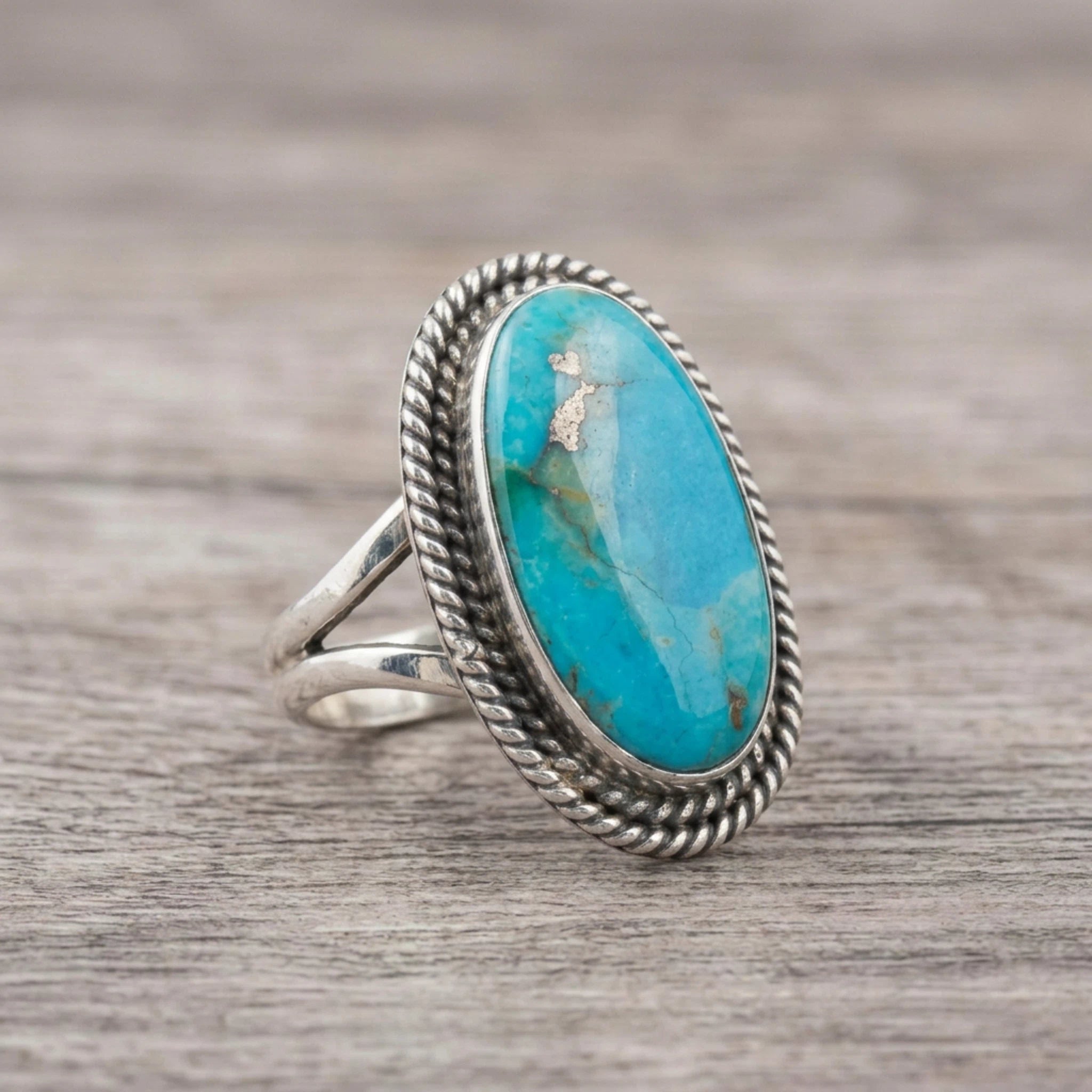 side view of a Sterling Silver Boho Ring with mohave turquoise gemstone on a wooden surface