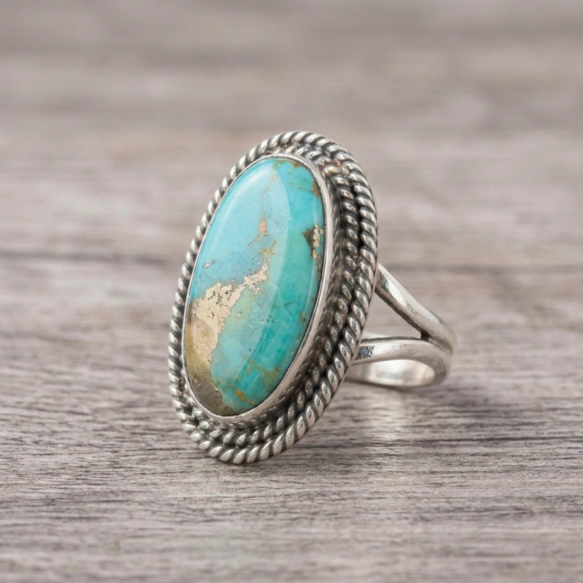 side view of a Sterling Silver Boho Ring with mohave turquoise gemstone on a wooden surface
