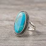 side view of a Sterling Silver Boho Ring with mohave blue turquoise gemstone on a wooden surface