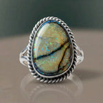 Monarch Opal Ring with a golden opal and dark matrix lines in a sterling silver rope bezel, close-up